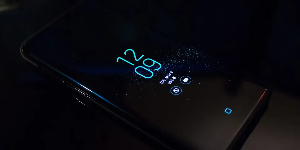 Smartphone mit dunklem Display auf einer Tischplatte